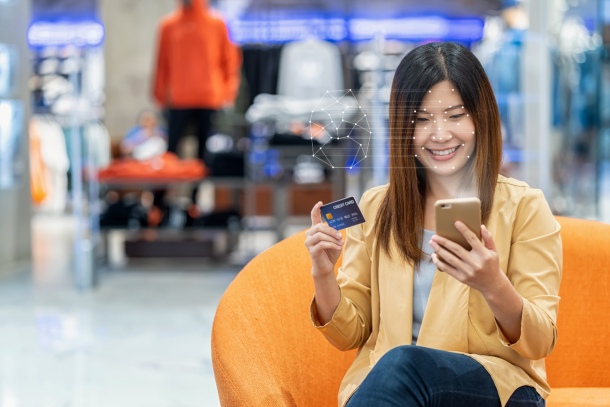 Asian woman using face recognition AI technologi for authentication